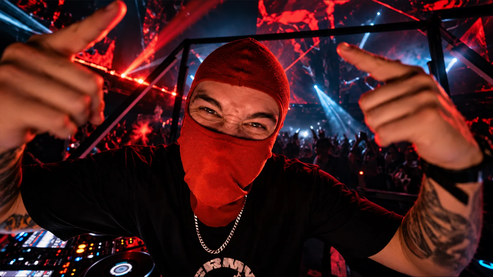 ANTIK con pasamontañas rojo señalando a cámara desde la cabina de DJ, con la sala llena al fondo